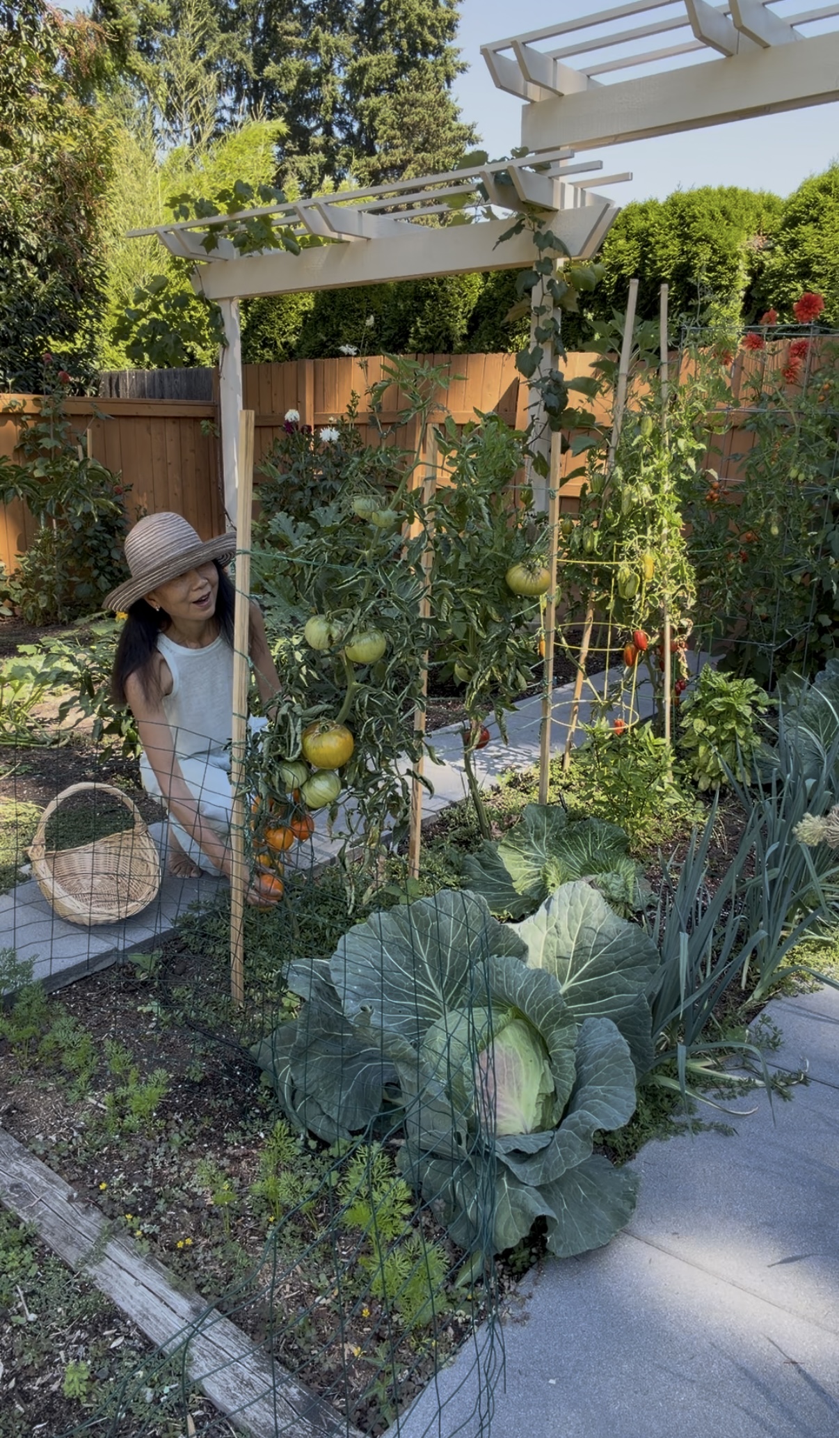 Janney kneeling with a basket beside a giant cabbage