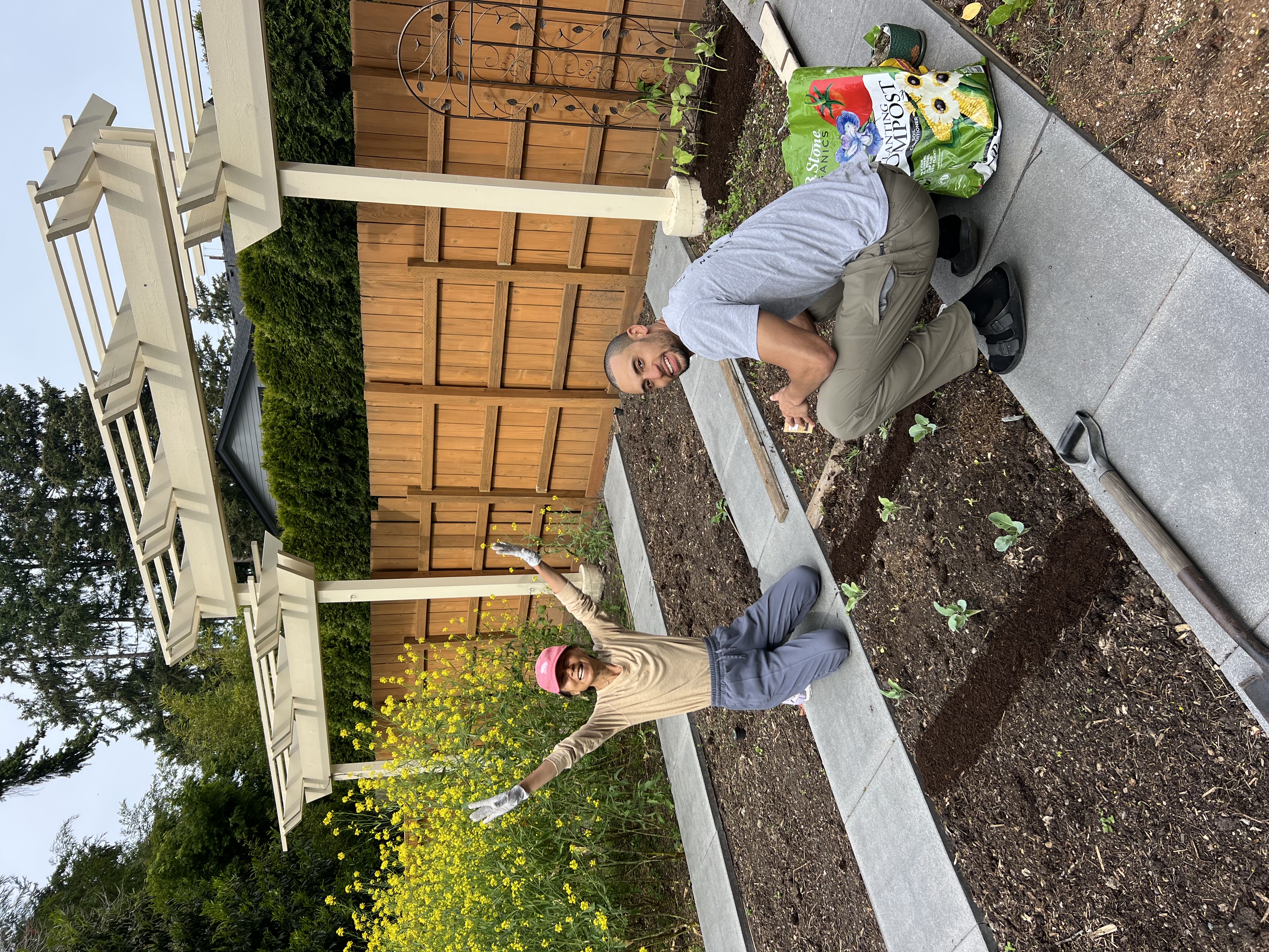 Janney kneeling in a freshly planted bed of seedlings